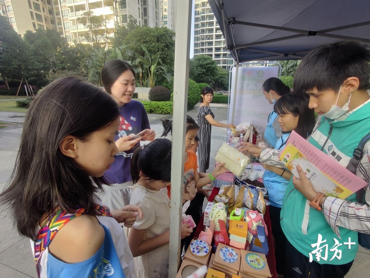 残疾学员茹志鹏与小朋友互动并向他们介绍产品