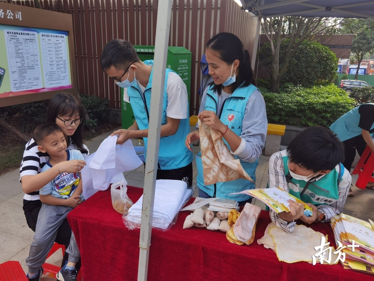 社工与残疾学员茹志鹏一起指导小朋友体验手工草木印染