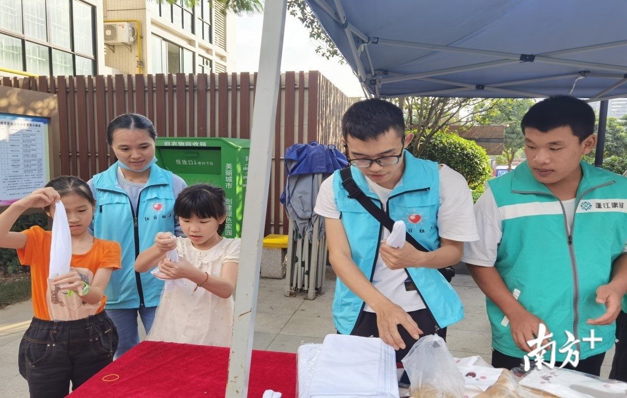 社工与残疾学员肖建荣一起指导小朋友体验手工草木印染