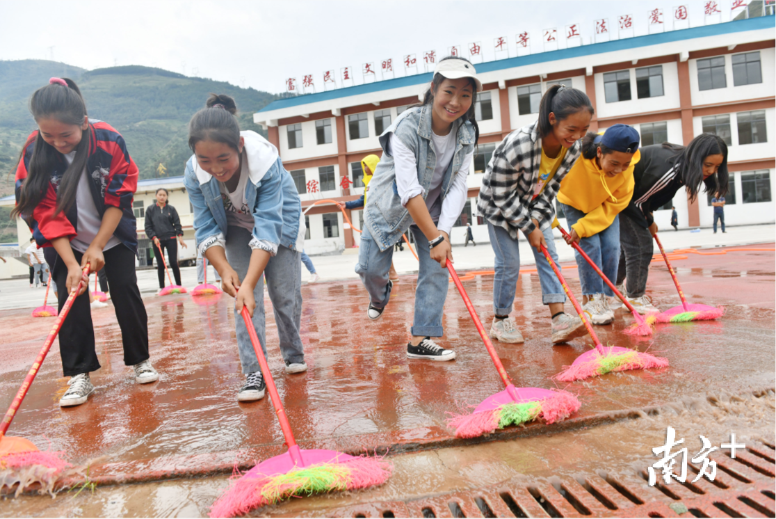  美姑县大桥初级中学的同学在清洁顺德援建的塑胶跑道。