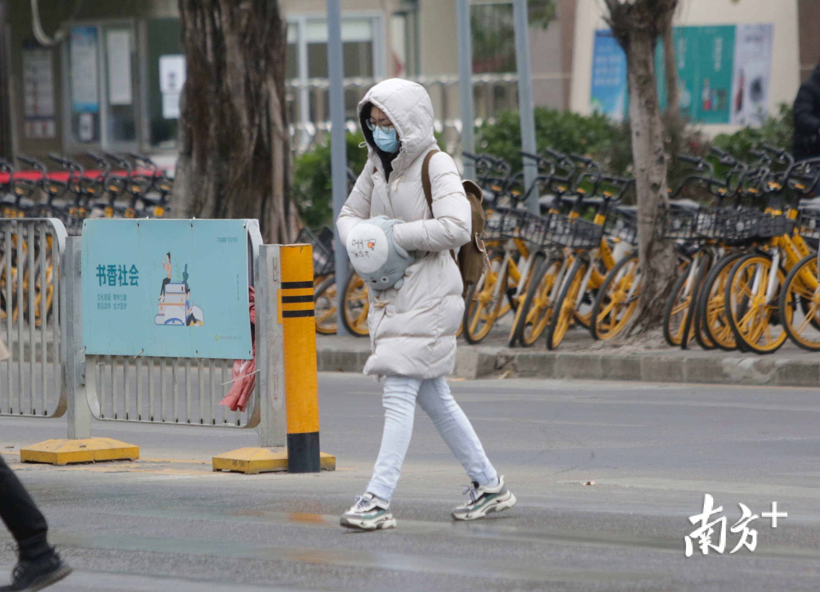 深圳冷空气来袭，8日早高峰，深圳宝安区航空路与顺昌路十字路口，出行上班的市民身穿厚厚的冬衣加快上班的脚步。