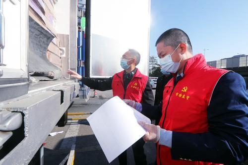 ▲邓华镔（右）和同事正在查验车辆货物单据