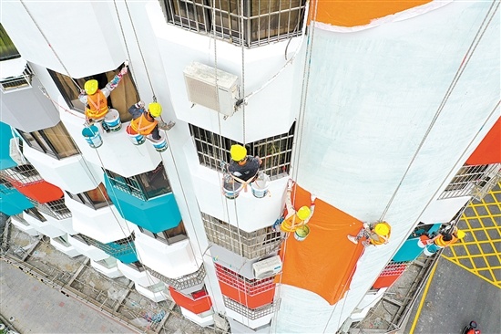 施工队员们正在大楼墙上“绣花”。