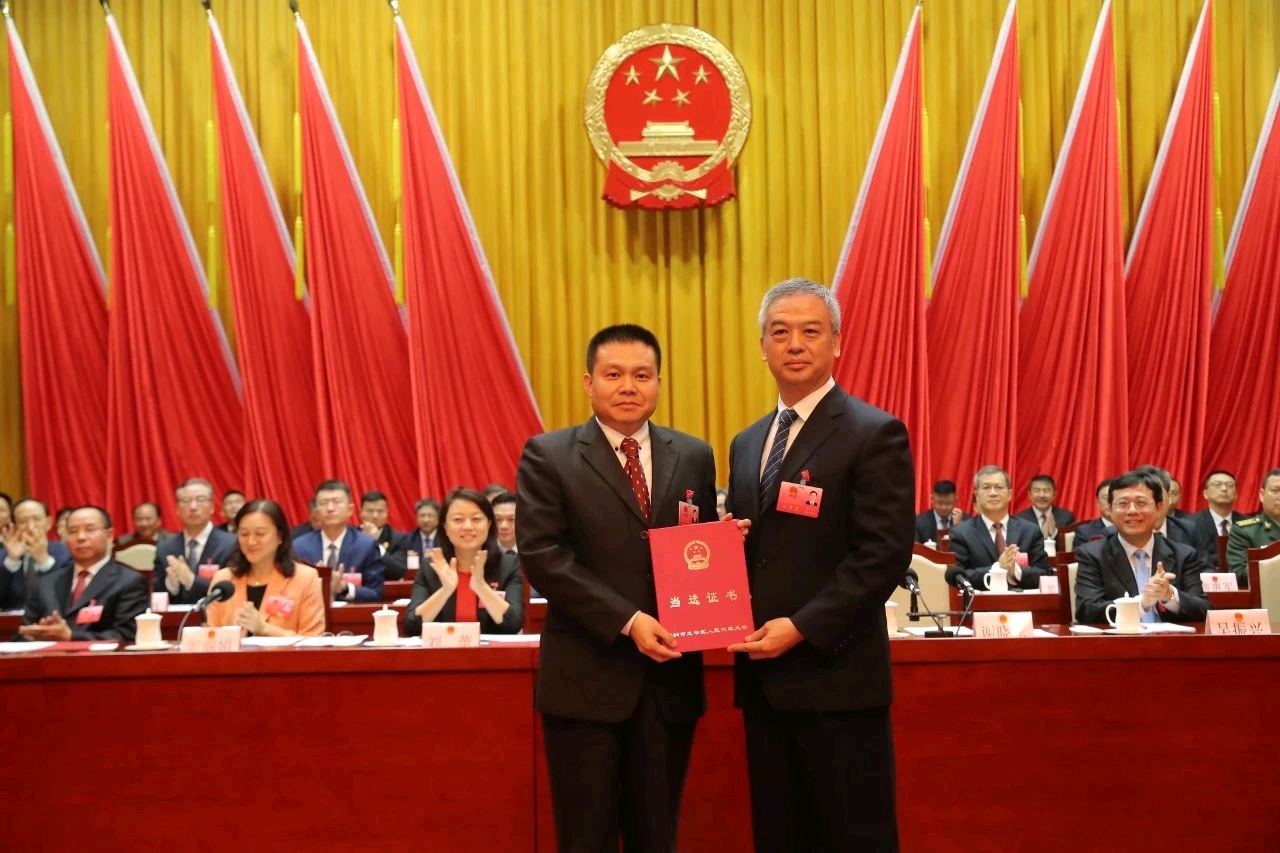 龙华区人大常委会主任谢晓东（前右）为新当选区长雷卫华（前左）颁发当选证书。