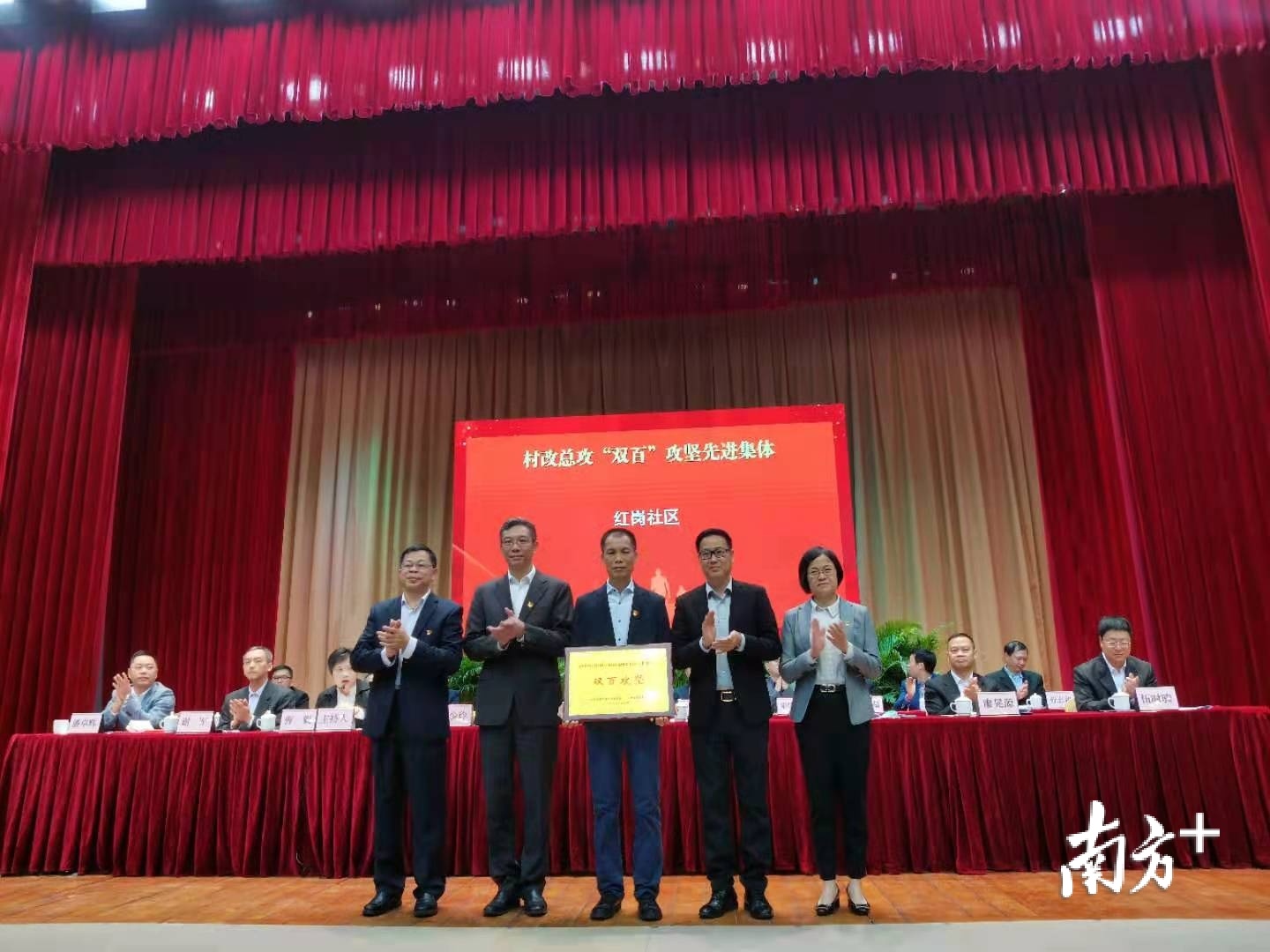 会议现场为村改总攻“双百”攻坚先进集体颁奖。熊程 摄