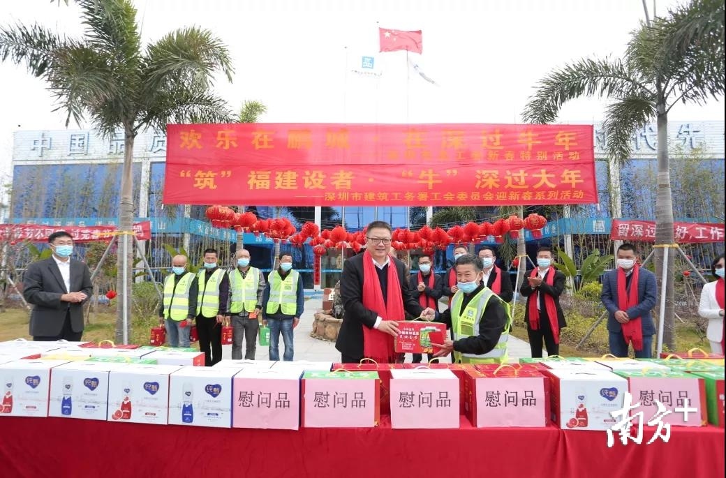 姚亮一行将慰问物资送到留深过年的建设者手中