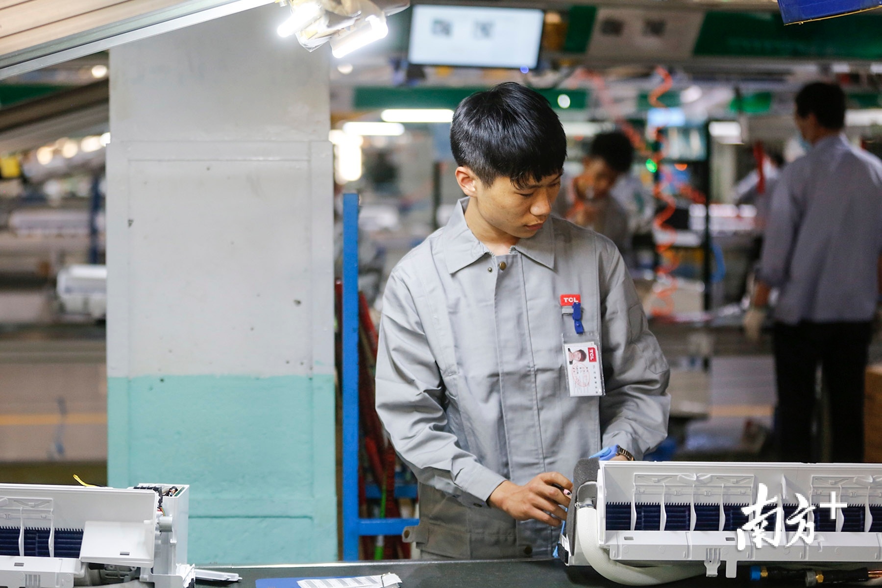 来自贵州省六盘水市的务工人员在TCL中山工厂生产线上工作。