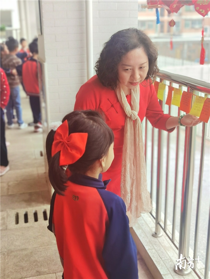 丰泰小学校长梁婉清与学生一起猜灯谜。