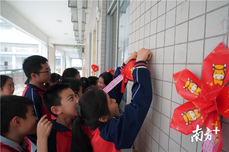 景贤小学学生将精心制作好的灯笼挂在教室外面，到处洋溢着喜庆的气氛。（2）