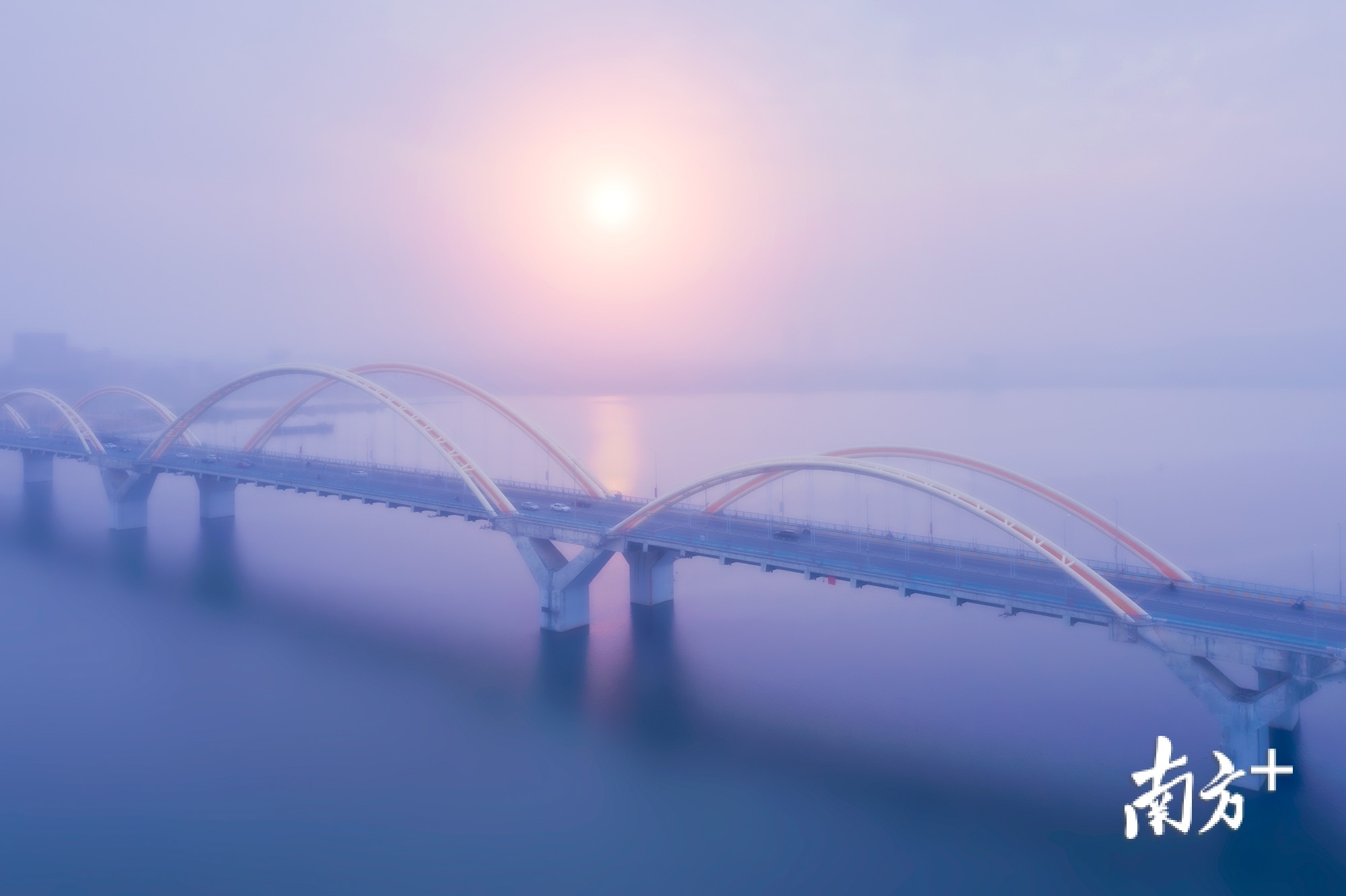 骄阳穿过薄雾，映照金山大桥。林文强 摄