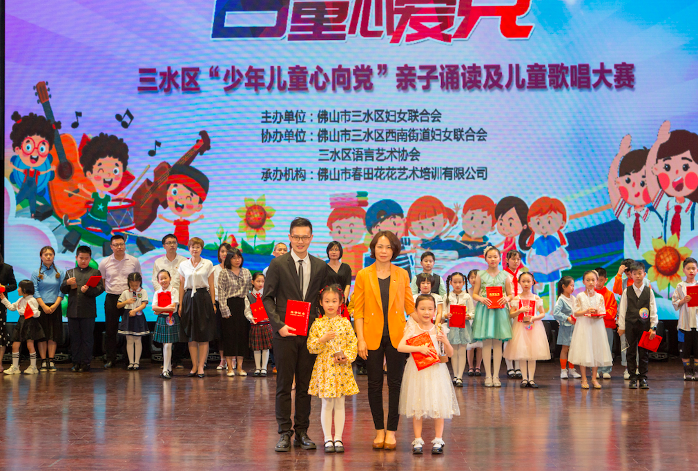 三水区妇联主席梁咏梅为获得一等奖的廖书吟家庭和绕梁之音合唱团颁奖。部门供图