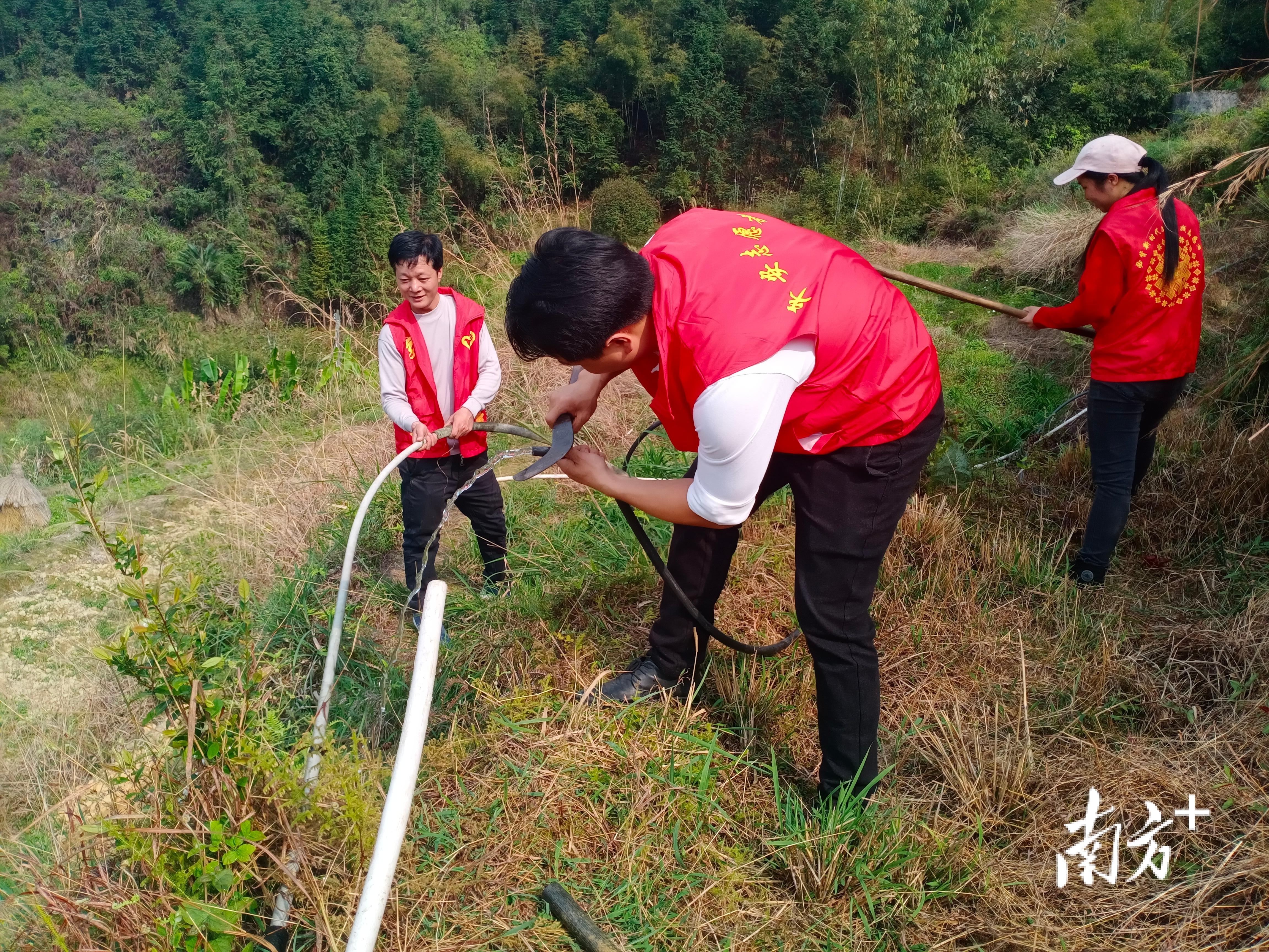 乳源县半坑村“两委”干部为困难群众接通水管，纾解饮用水困难。通讯员供图