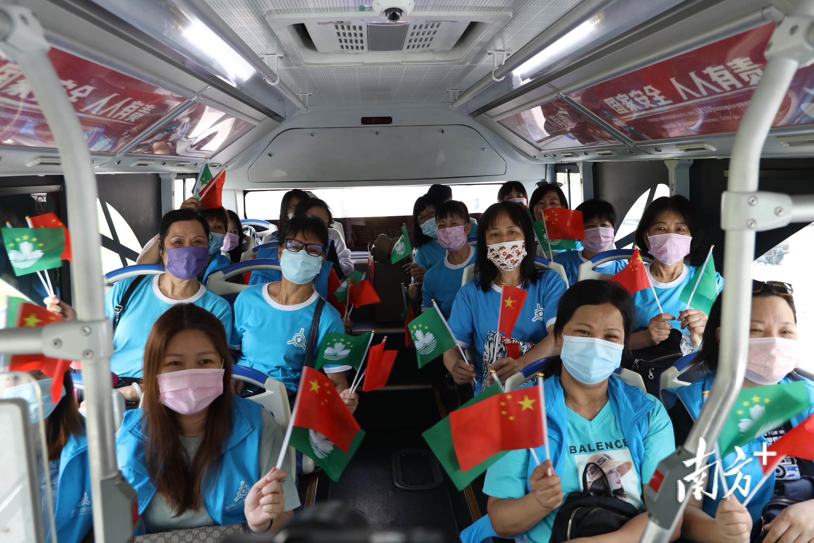 澳门同胞在“国安号”上挥舞国旗与澳门特别行政区区旗。