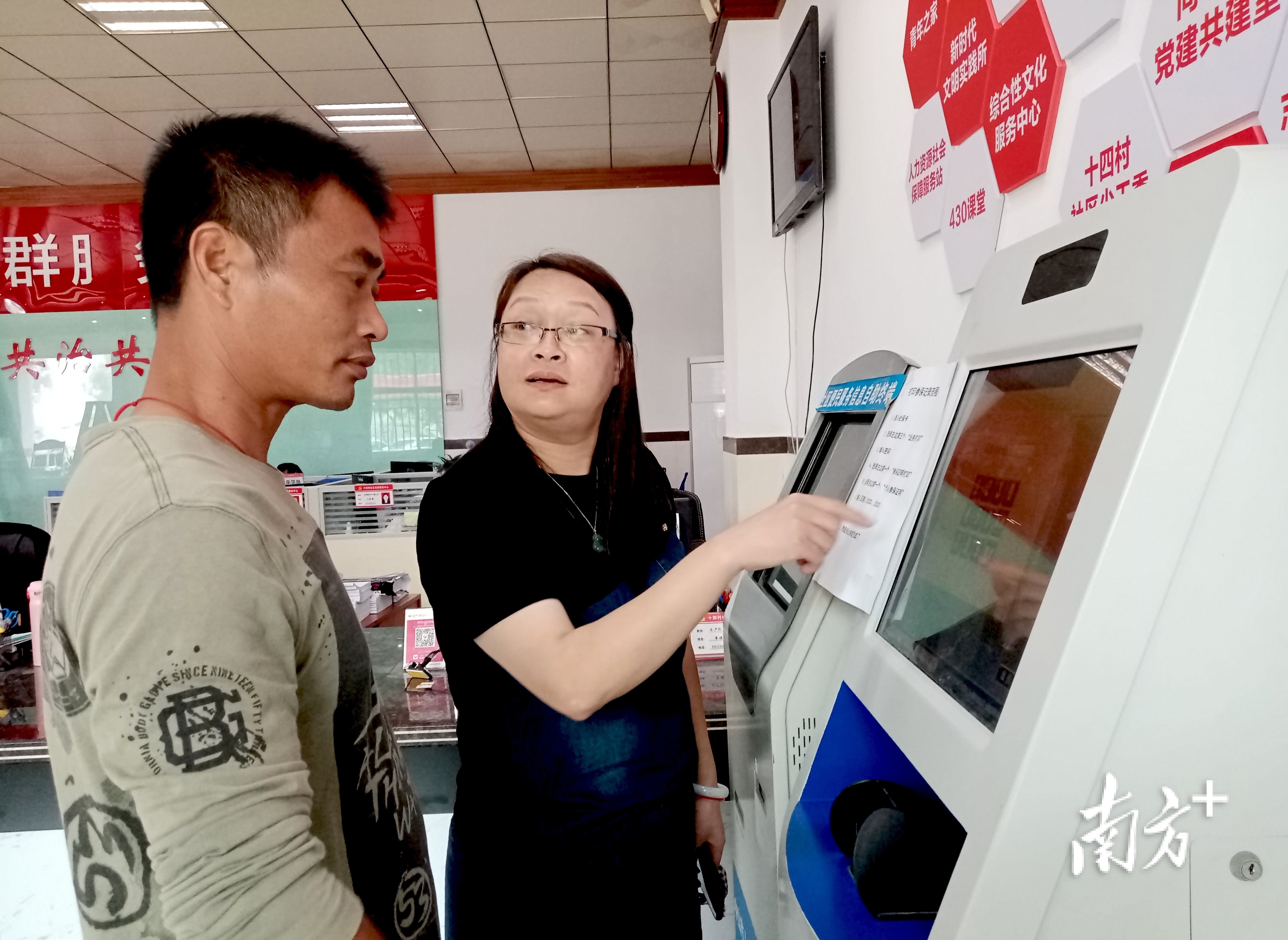 社区党群服务中心综合服务大厅工作人员正在指引十四村村民张桂洪办理政务事项。