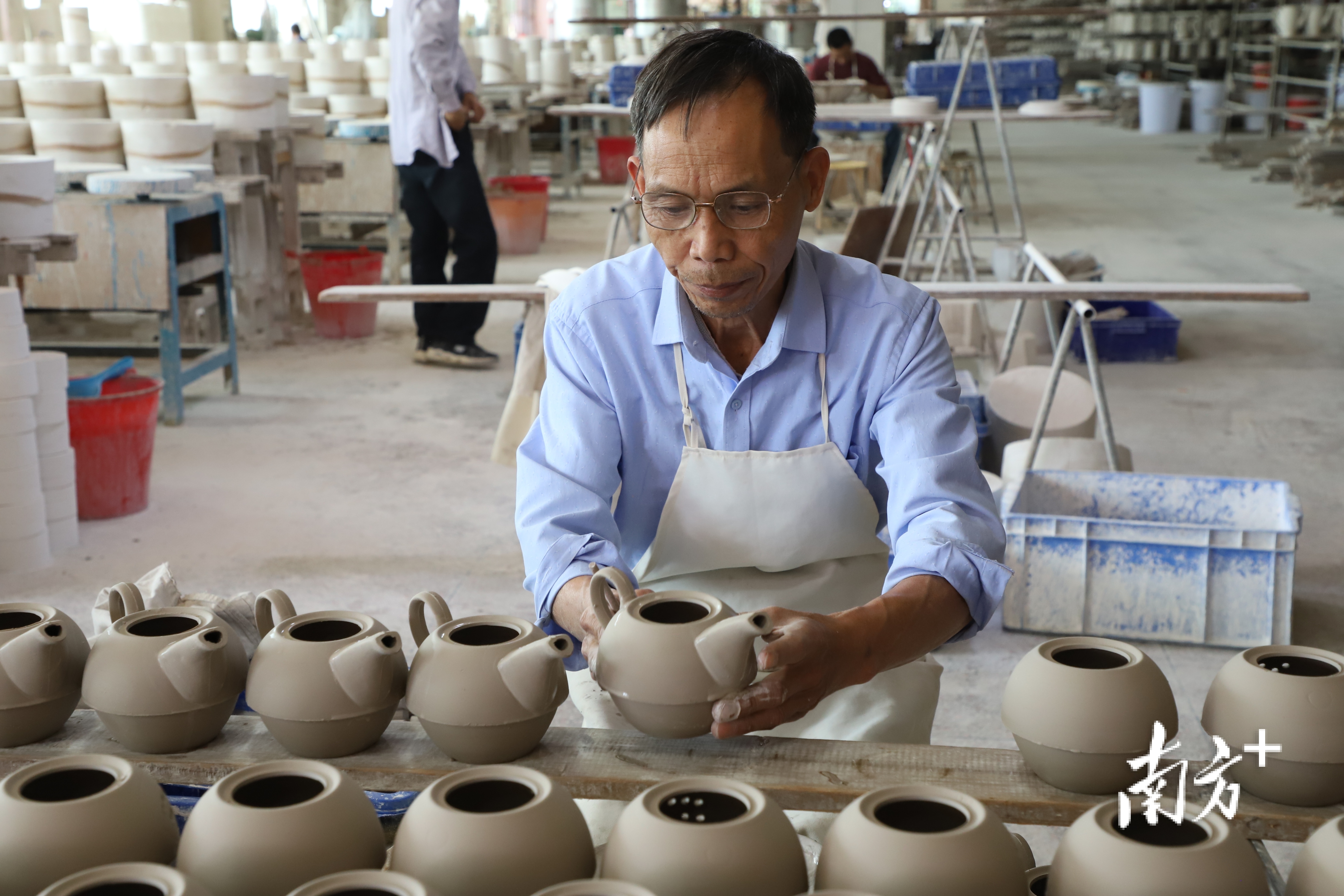 工人熟练地安装壶把。