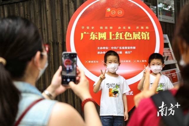 “五一”假期，不少家长带着孩子前往毛泽东同志主办农民运动讲习所旧址纪念馆游览参观。图为孩子在广东网上红色展馆拍照板前合影留念。南方日报记者 张迪 实习生 姚佳烁 摄