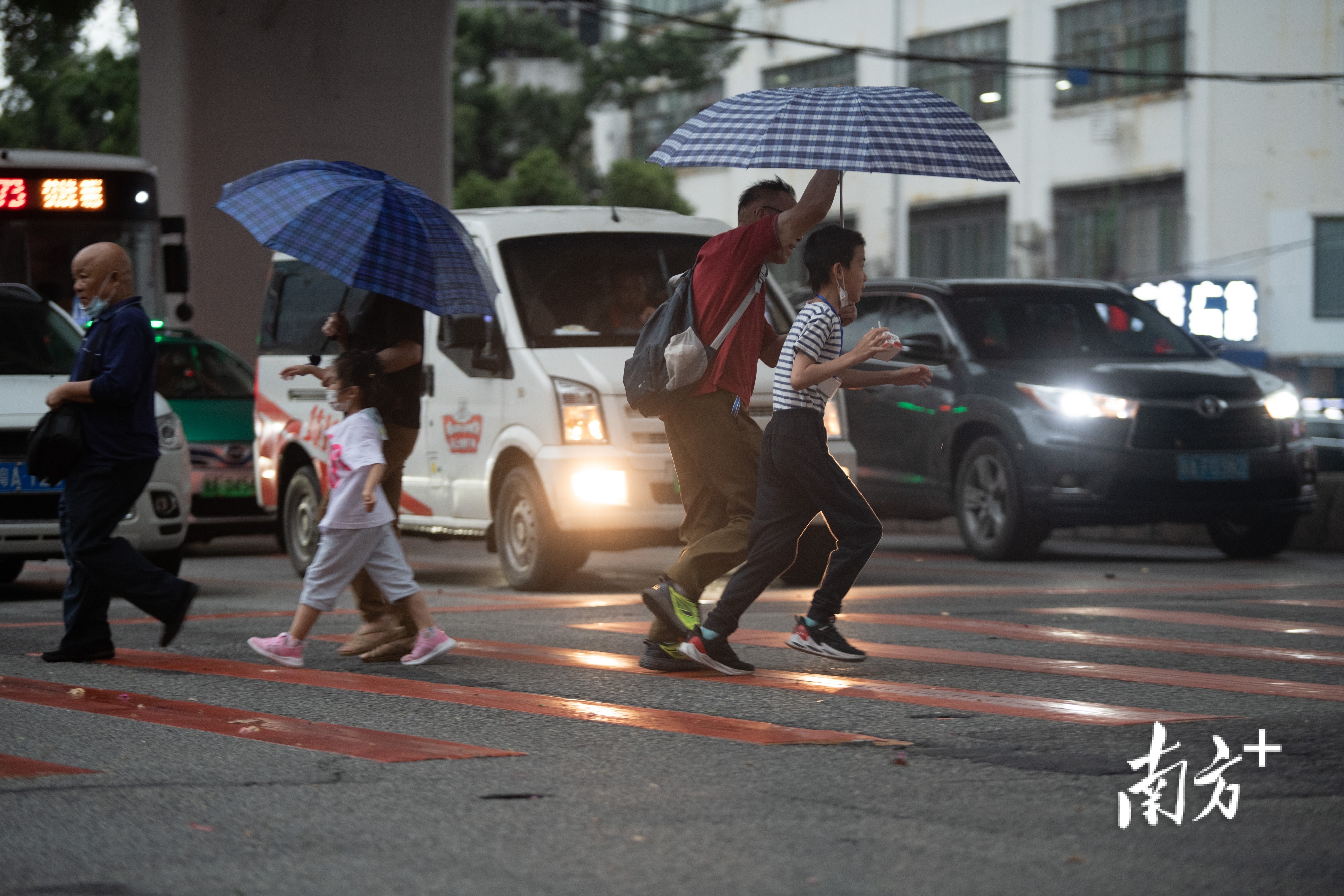 市民撑着雨伞迎风奔跑。 市民撑着雨伞迎风奔跑。