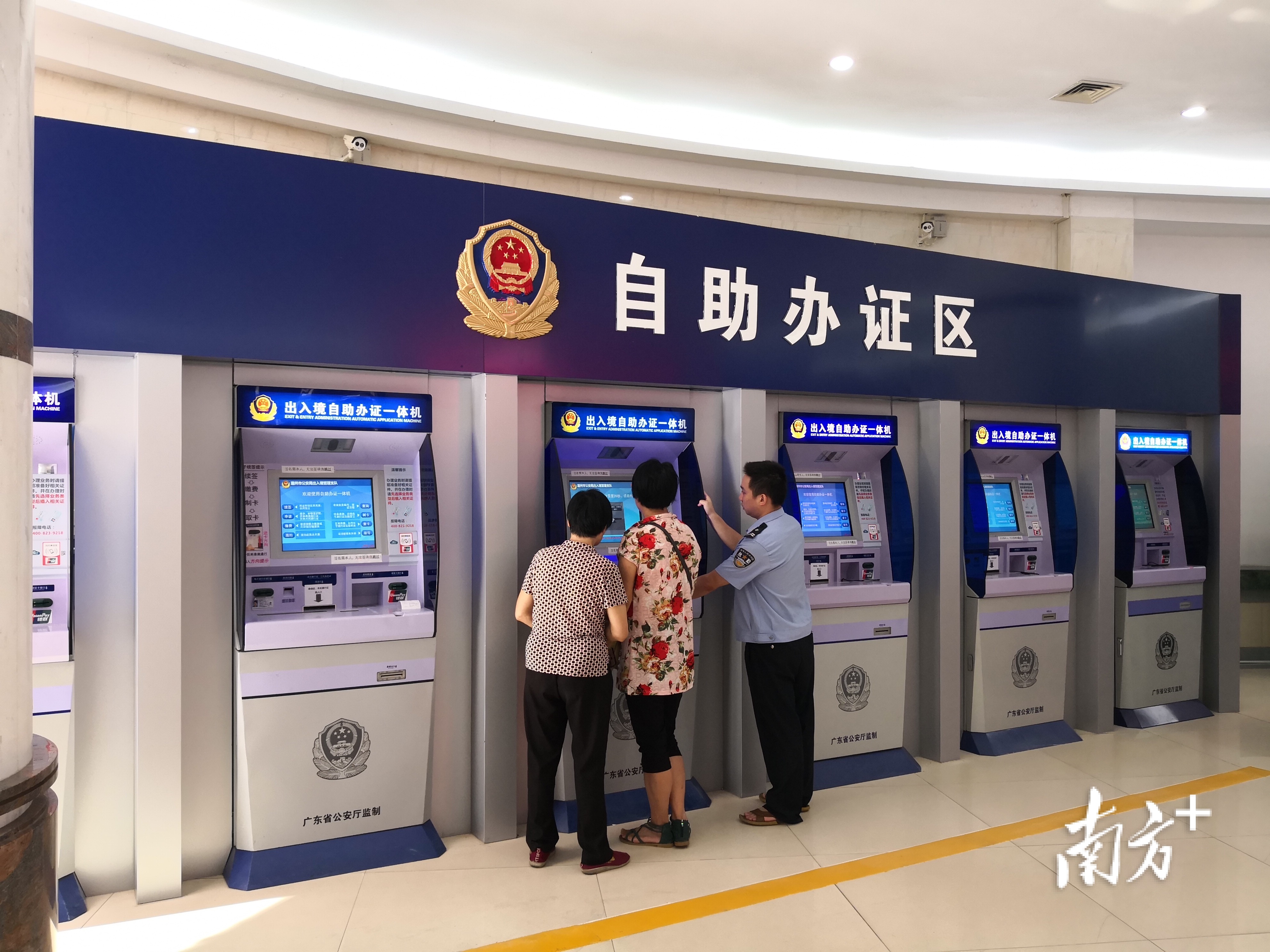 工作人员耐心指导群众使用自助办证一体机。