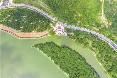 在二沙岛绿道上散步的游人途经波浪状的美丽花景。