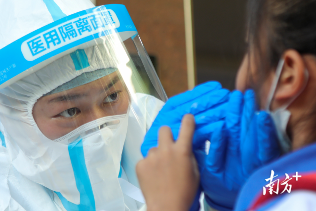 5月29日，深圳市龙岗区四联小学核酸采样点。医护人员正在为居民进行核酸采样，他们眼神里透着坚毅、认真。