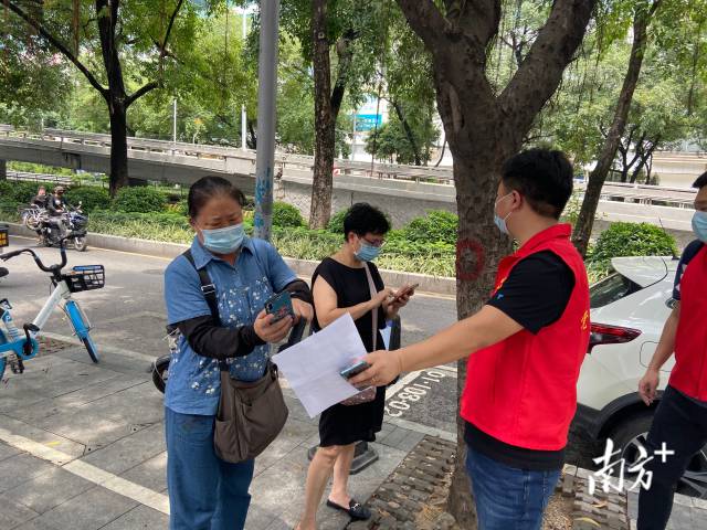 “阿婆，你可以扫码回家先填表，如果人多就先回家，等人少了再来。”在越秀区黄花岗街区庄的核酸检测点，工作人员和志愿者对居民进行引导。南方日报、南方+记者 郭苏莹