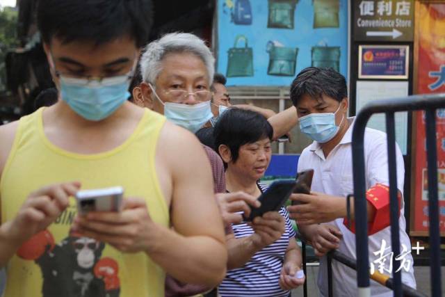 早上九点半，登峰街登峰宾馆门前检测点已搭建完毕，周边居民陆续前来排队做核酸检测，队伍中有社区工作人员逐一教居民如何提前扫码完成登记。南方日报记者 梁钜聪 摄