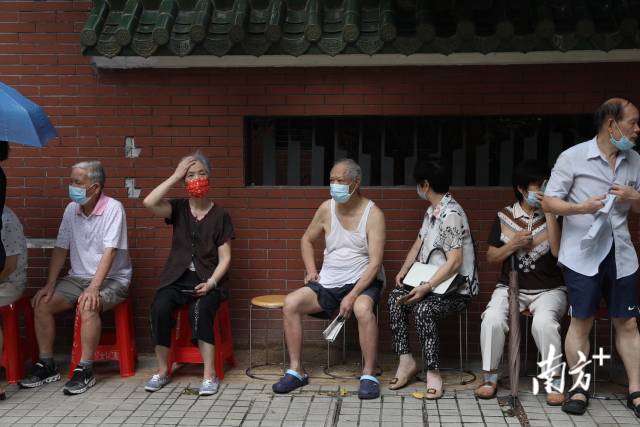 10：40【越秀区梅花街】上午10点半，梅花街富力新天地D区，周边居民有序排队等待核酸检测。老人被安排在阴凉处的特别队列，可以坐着等待。