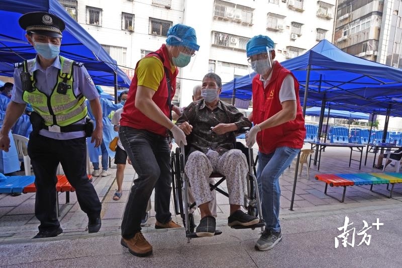 佛山市体育馆检测点，志愿者帮助行动不便的老人进入场馆检测。南方日报记者 戴嘉信 摄