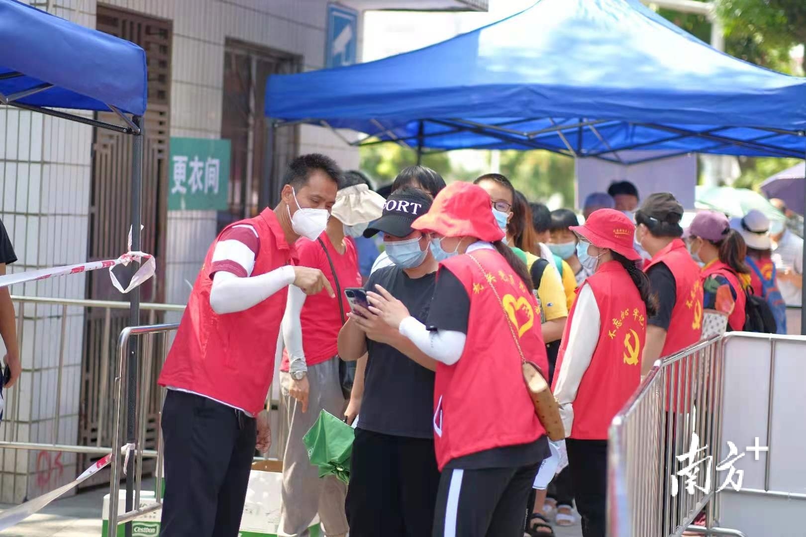 党员干部下沉一线，图为三水机关党员在核酸检测采样点服务群众。三水区档案局供图