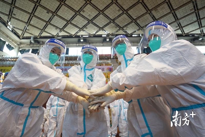 佛山市体育馆检测点，禅城区人民医院的医护工作者一起加油鼓劲。南方日报记者 戴嘉信 摄