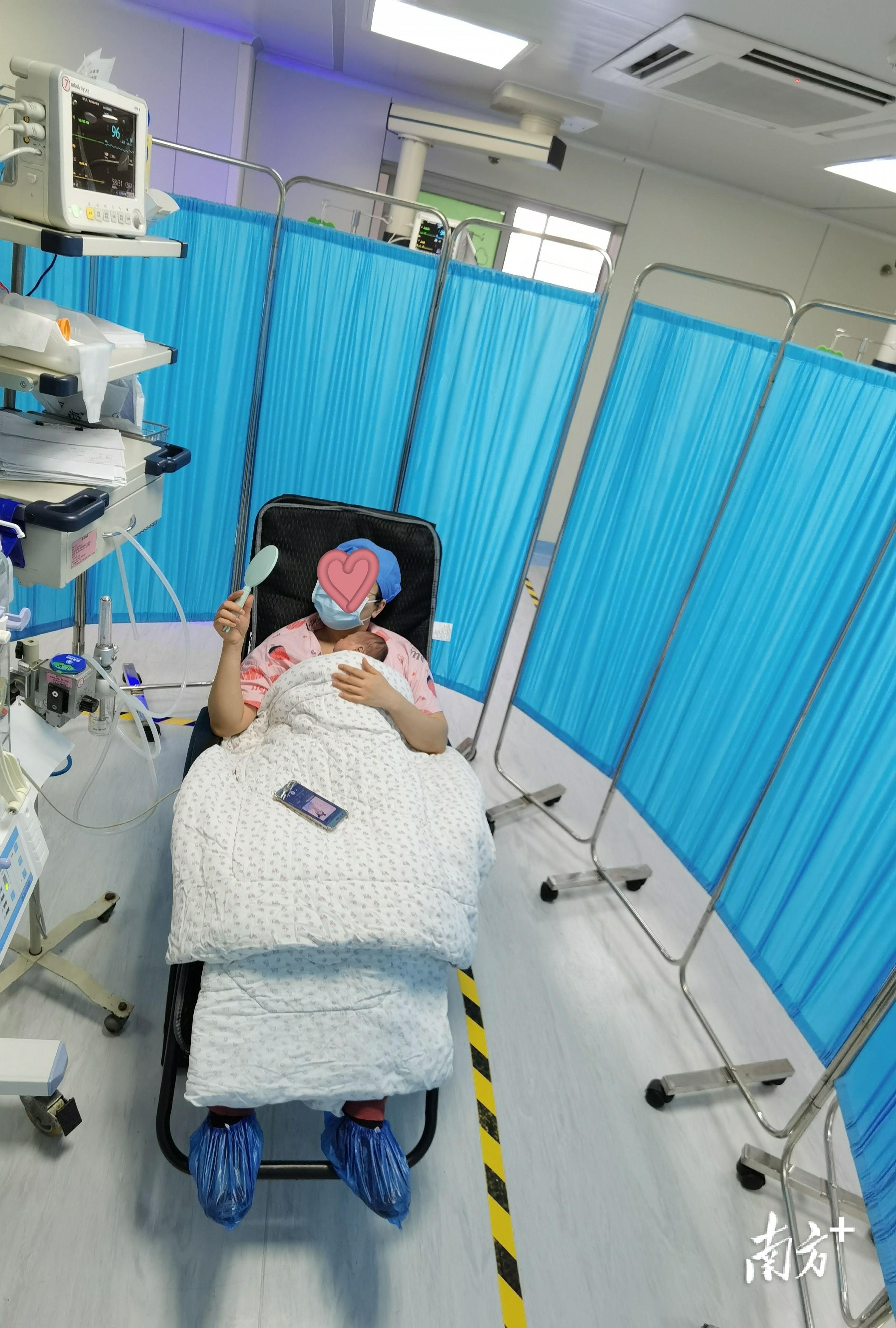 袋鼠式护理,妈妈拿着镜子可以观察宝宝的情况。