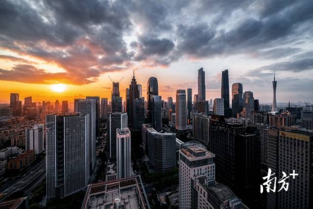 5月12日清晨，太阳从东方升起，金黄色的光芒照亮广州珠江新城建筑群。 逸松 摄