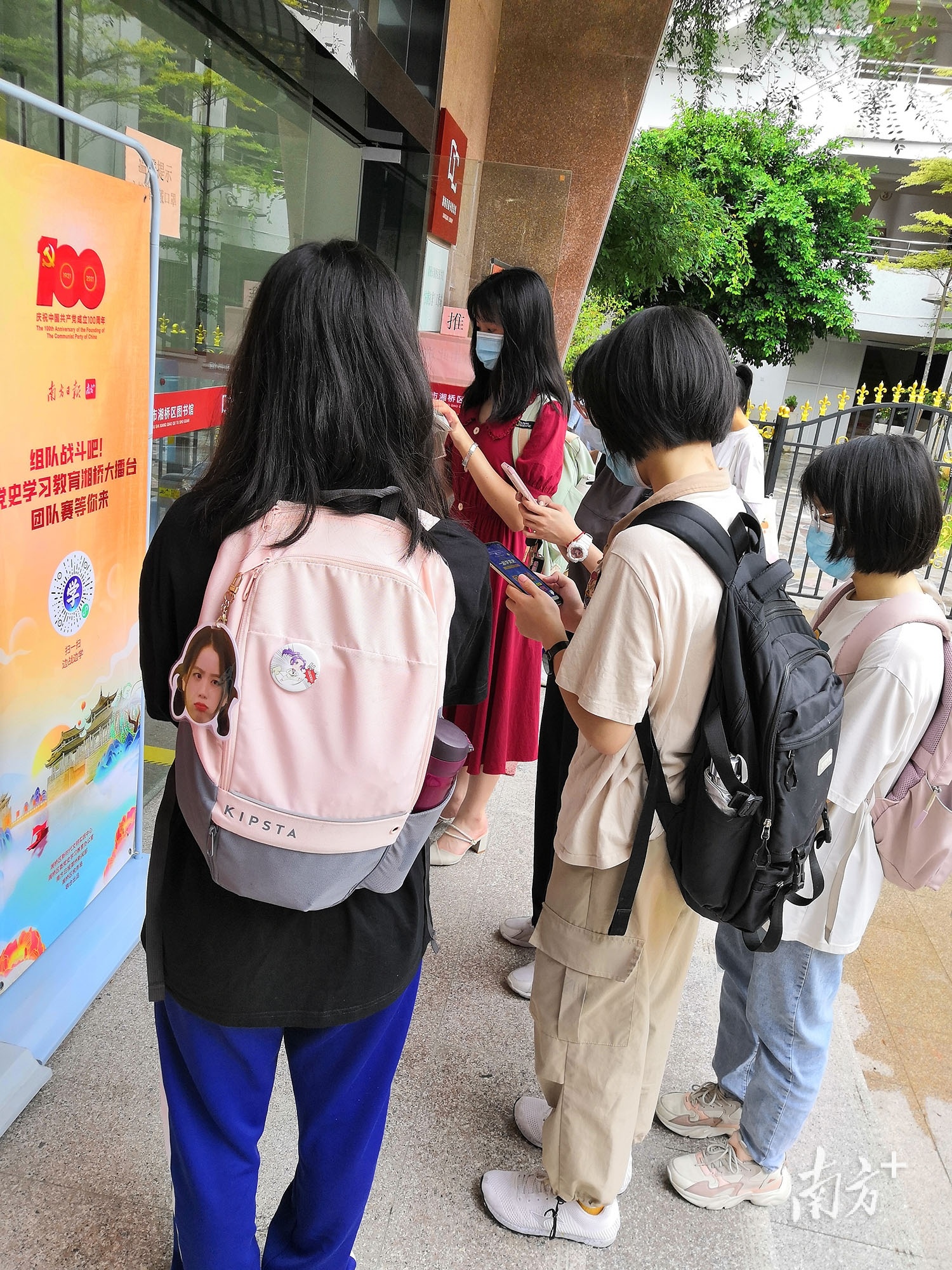 湘桥区图书馆门口,读者们通过扫码参加“党史学习湘桥大擂台”活动。