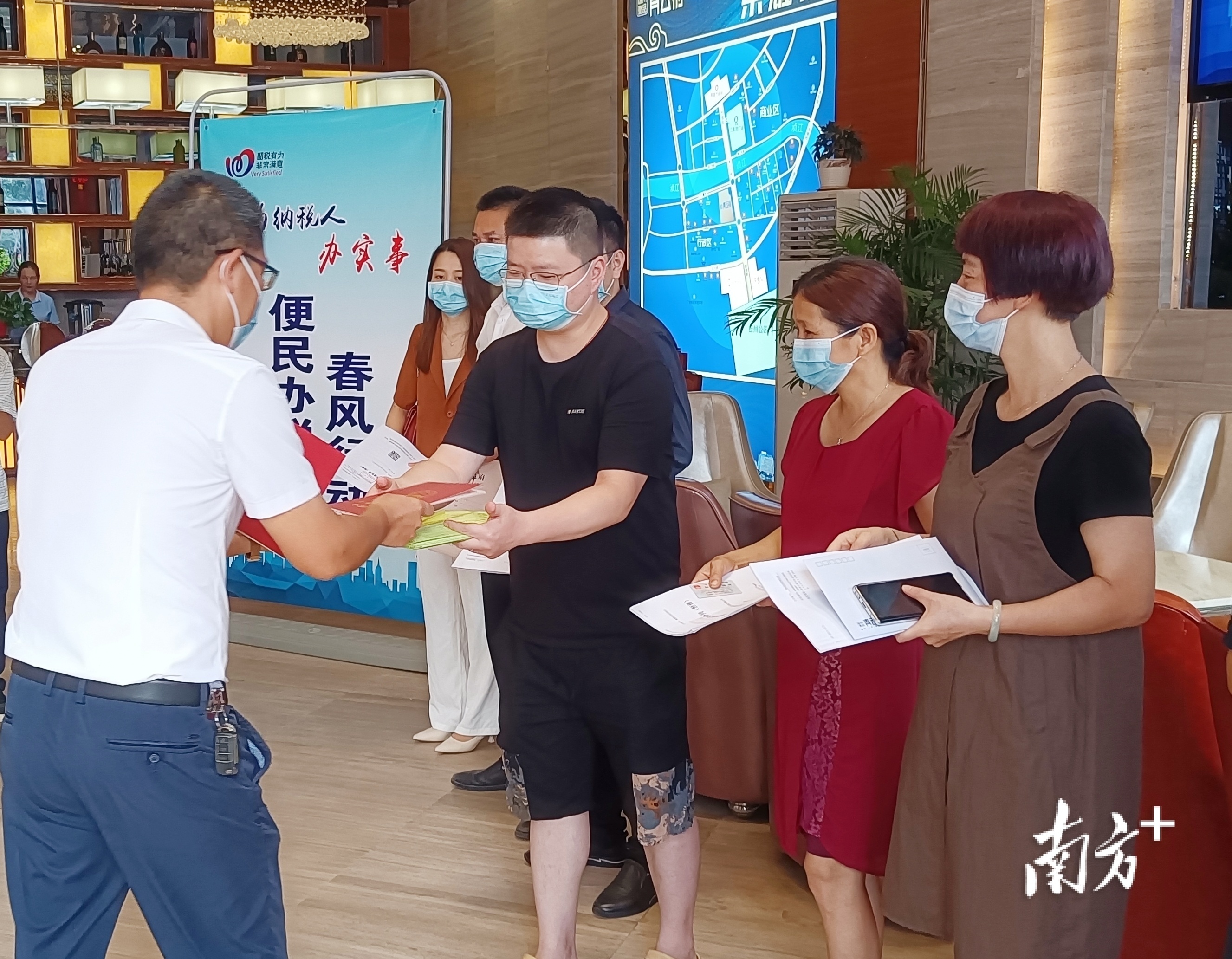 交房现场，8名业主代表在收楼的同时领取到不动产权证书。余丽娜 摄