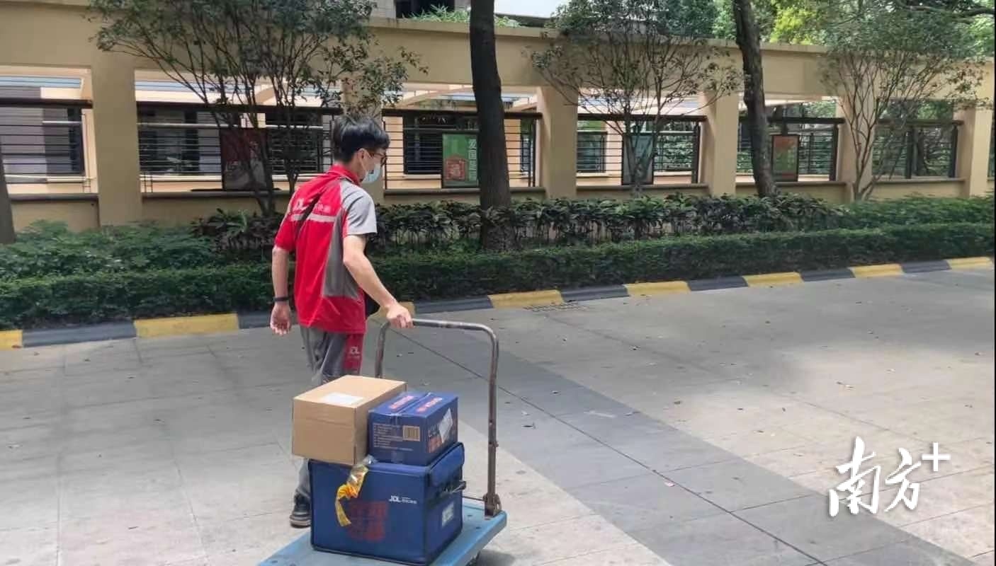 快递小哥谭志给小区居民们送快递。