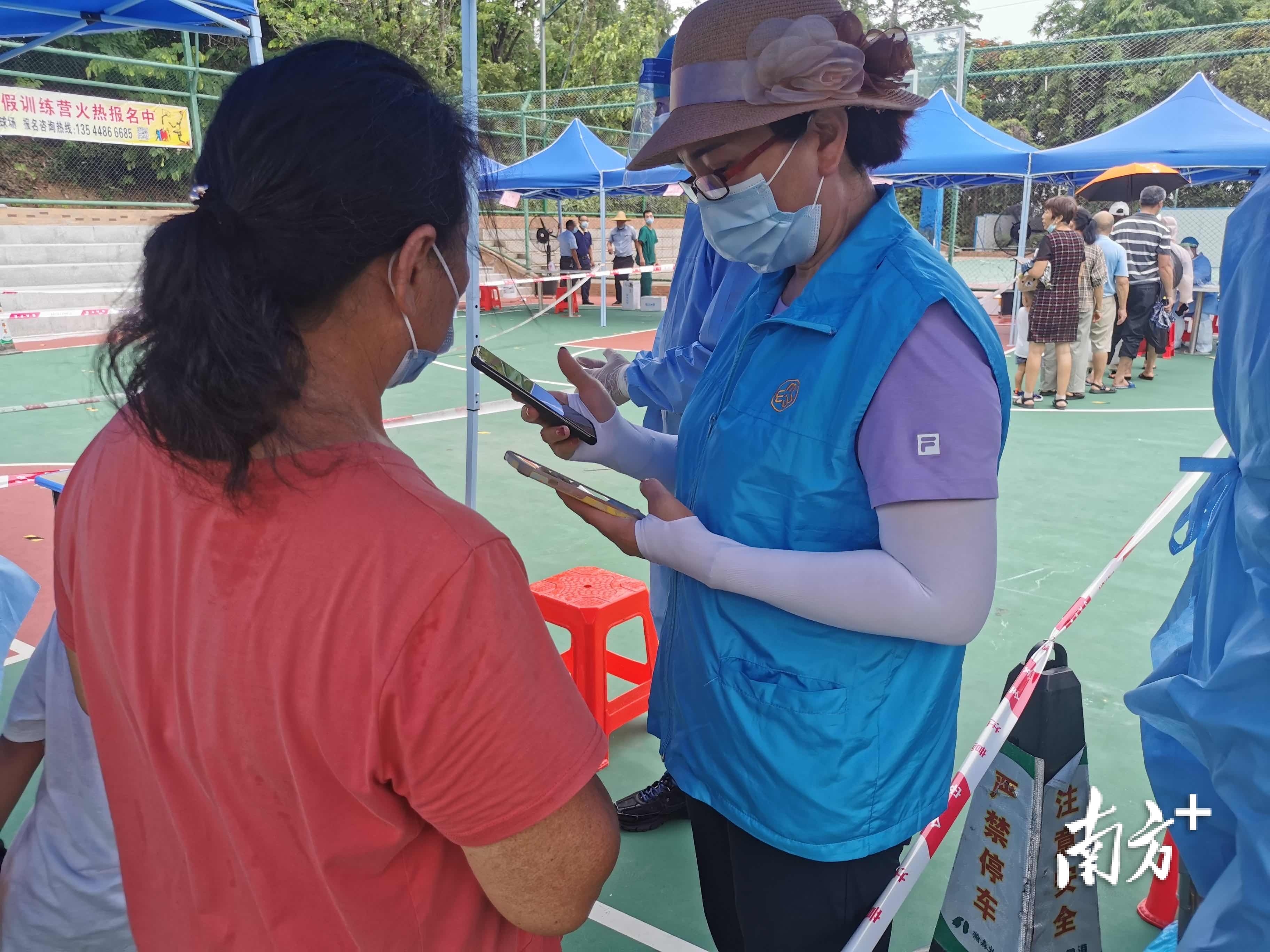 横沥”楼嫂“在核酸采样现场进行志愿服务。