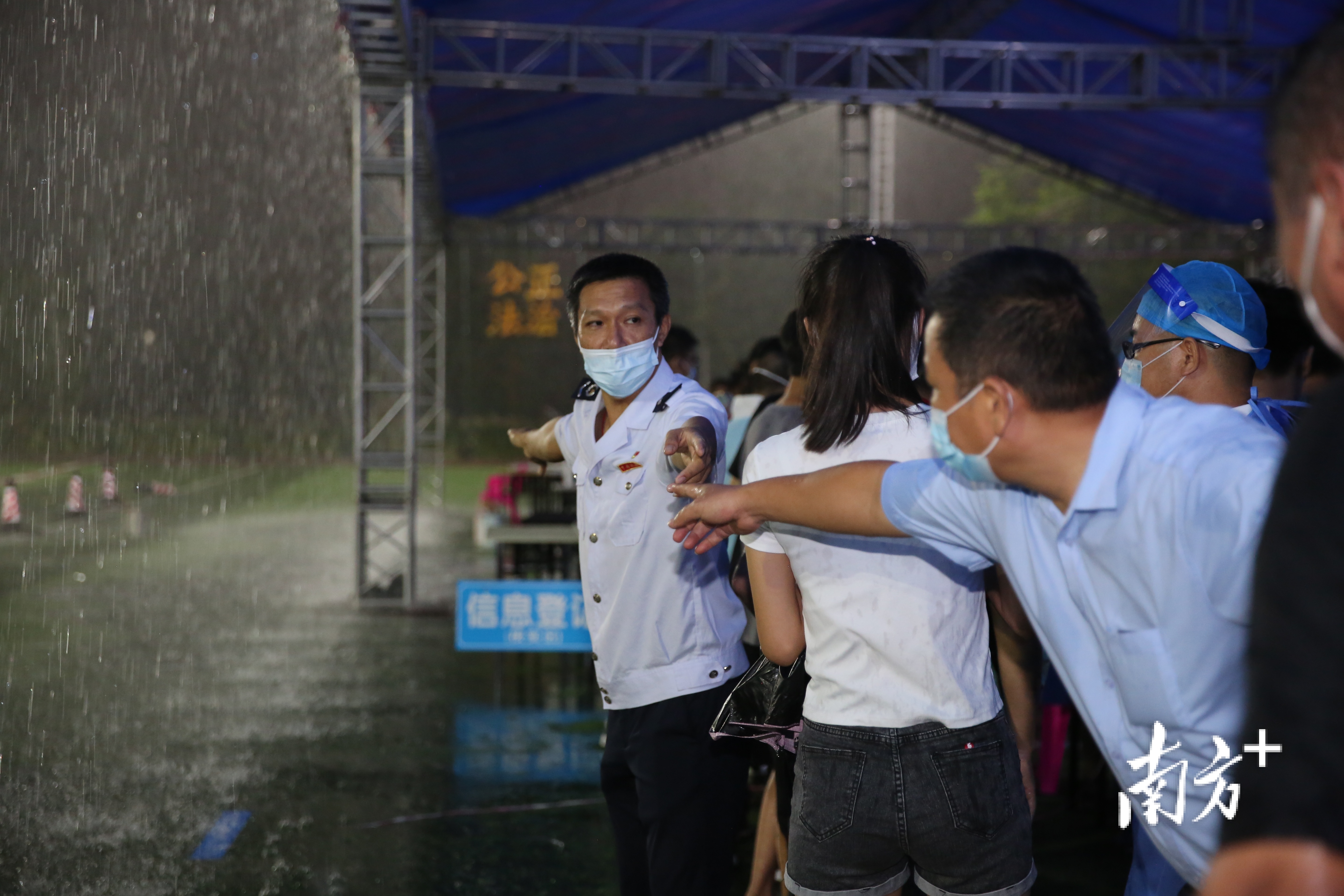 松山湖税务部门党员干部在大雨中全力维护核酸检测秩序。受访单位供图 松山湖税务部门党员干部在大雨中全力维护核酸检测秩序。受访单位供图