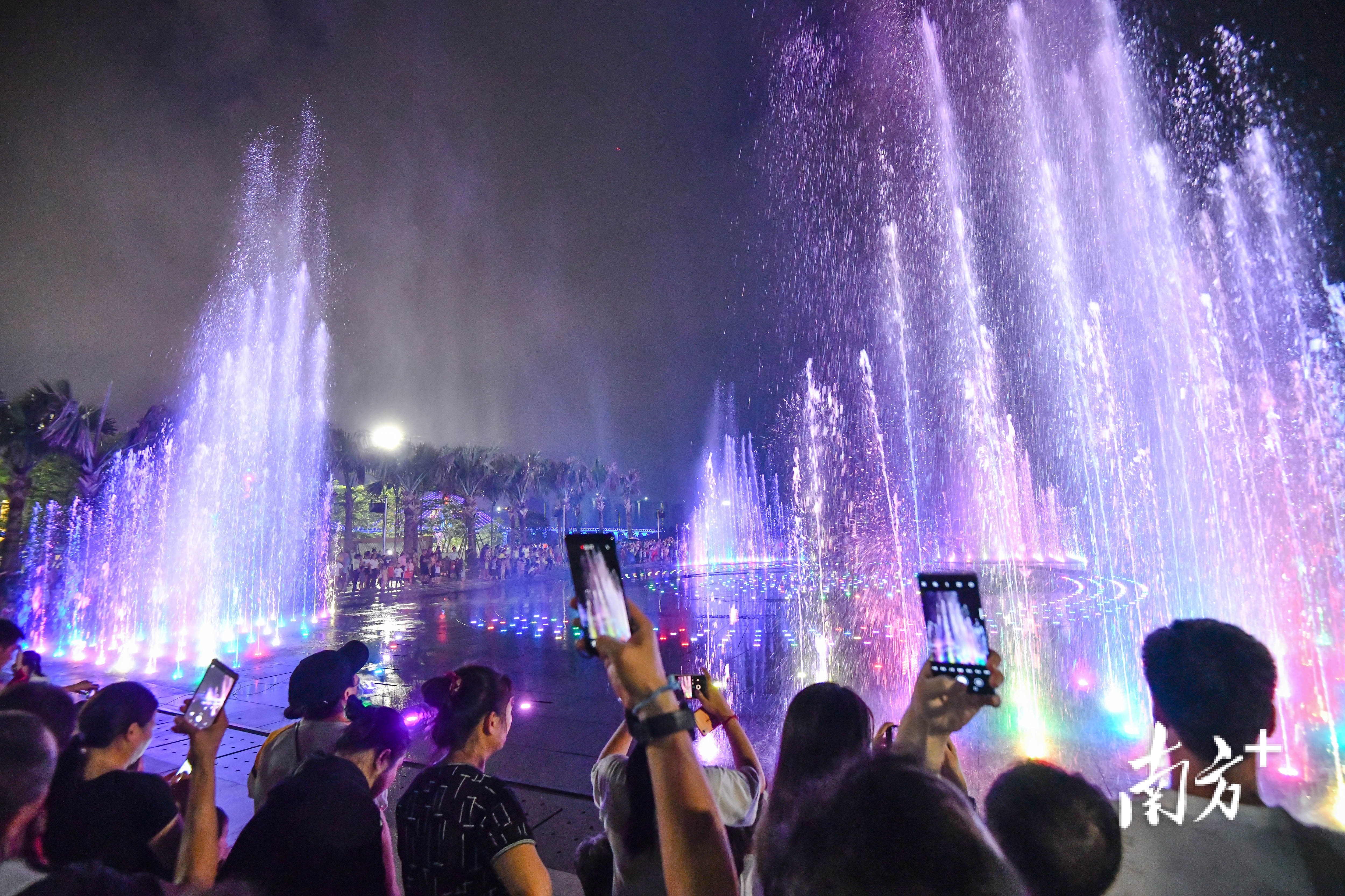 北江南岸公园喷泉广场,市民一边听着红歌一边给新开放的音乐喷泉拍照打卡。记者 曾亮超 摄 北江南岸公园喷泉广场,市民一边听着红歌一边给新开放的音乐喷泉拍照打卡。记者 曾亮超 摄