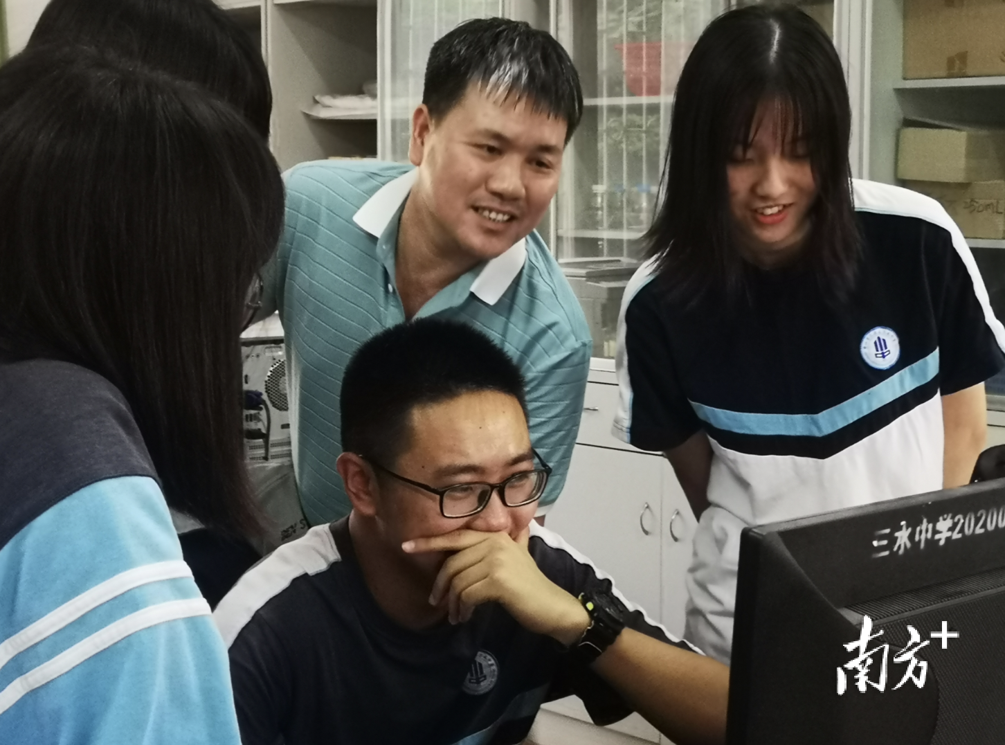 三水中学物理类翘楚(20)班班主任贺冬顺(右二)与学生一起查询高考成绩。 李周秦 摄 三水中学物理类翘楚(20)班班主任贺冬顺(右二)与学生一起查询高考成绩。 李周秦 摄