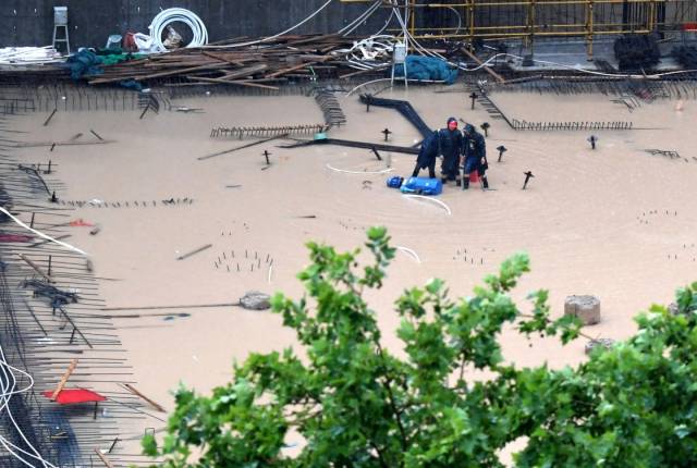 7月20日，工作人员在郑州市一建筑工地排水。  新华社 图