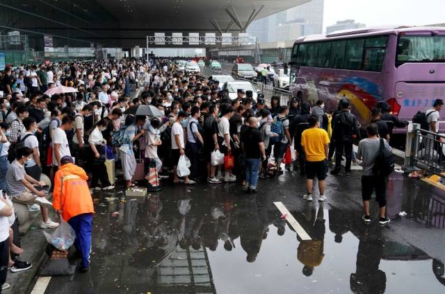 7月21日，滞留旅客在郑州东站进站口处排队登乘大巴车。