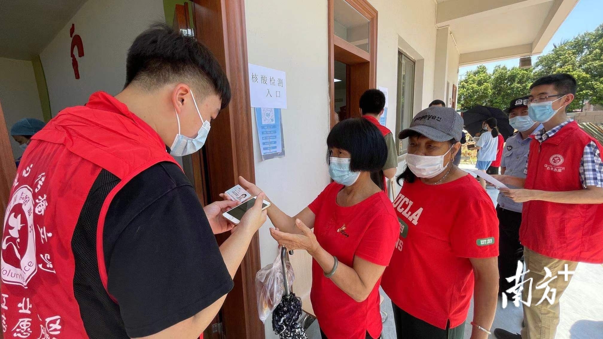 志愿者在现场指引群众提前扫码“粤核酸”，村民填写好相关信息后再进入检测区，可大大缩短检测时间。