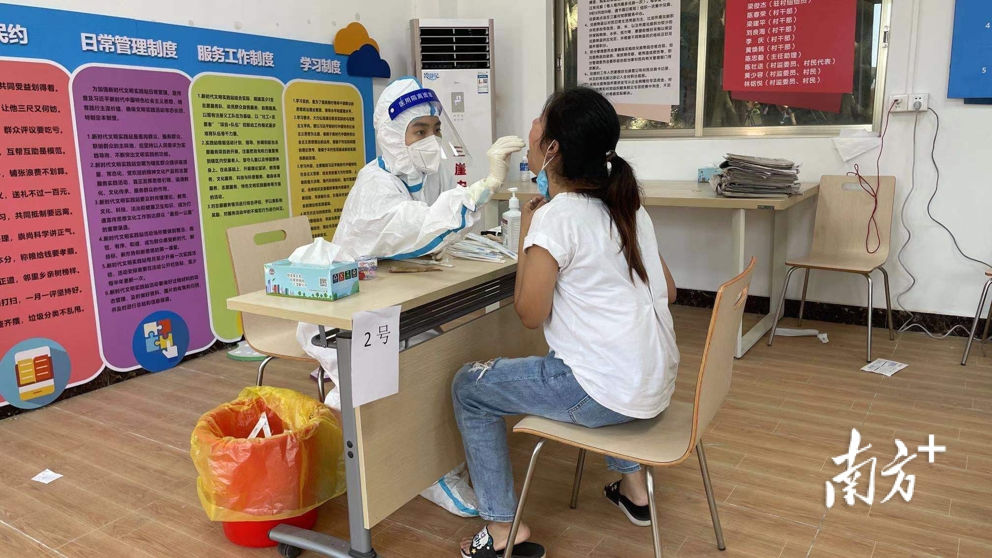 在三崖村委会核酸检测点，村民陆续前来排队进行核酸检测。