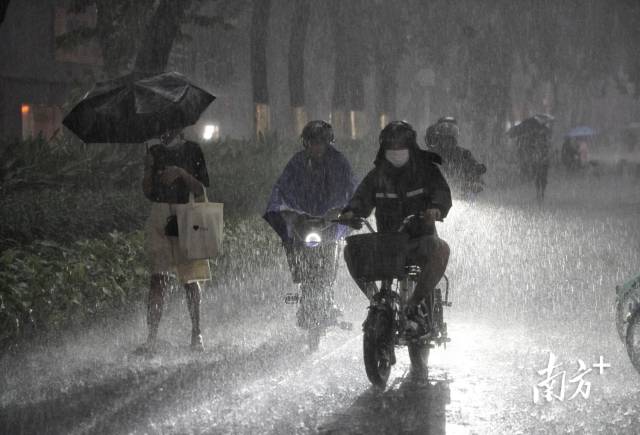  7月28日，暴雨叠加晚高峰，广州大道中的市民在雨中前行。