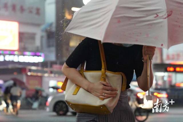 7月28日下午5点半，东晓南路刮起大风，雷雨交加中行人持伞快速前行。