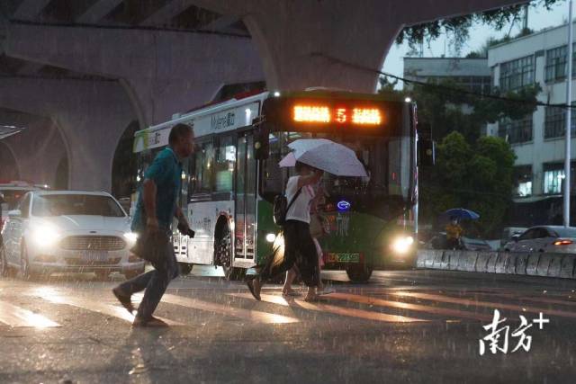  7月28日下午5点半，东晓南路刮起大风，雷雨交加中行人持伞快速前行。
