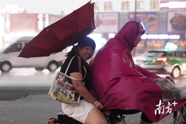  7月28日下午5点半，东晓南路刮起大风，雷雨交加中行人持伞快速前行。