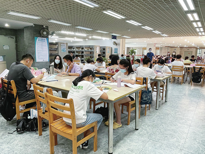 市图书馆阅览区内,市民做好个人防护措施安静地阅读学习.陈明红 摄