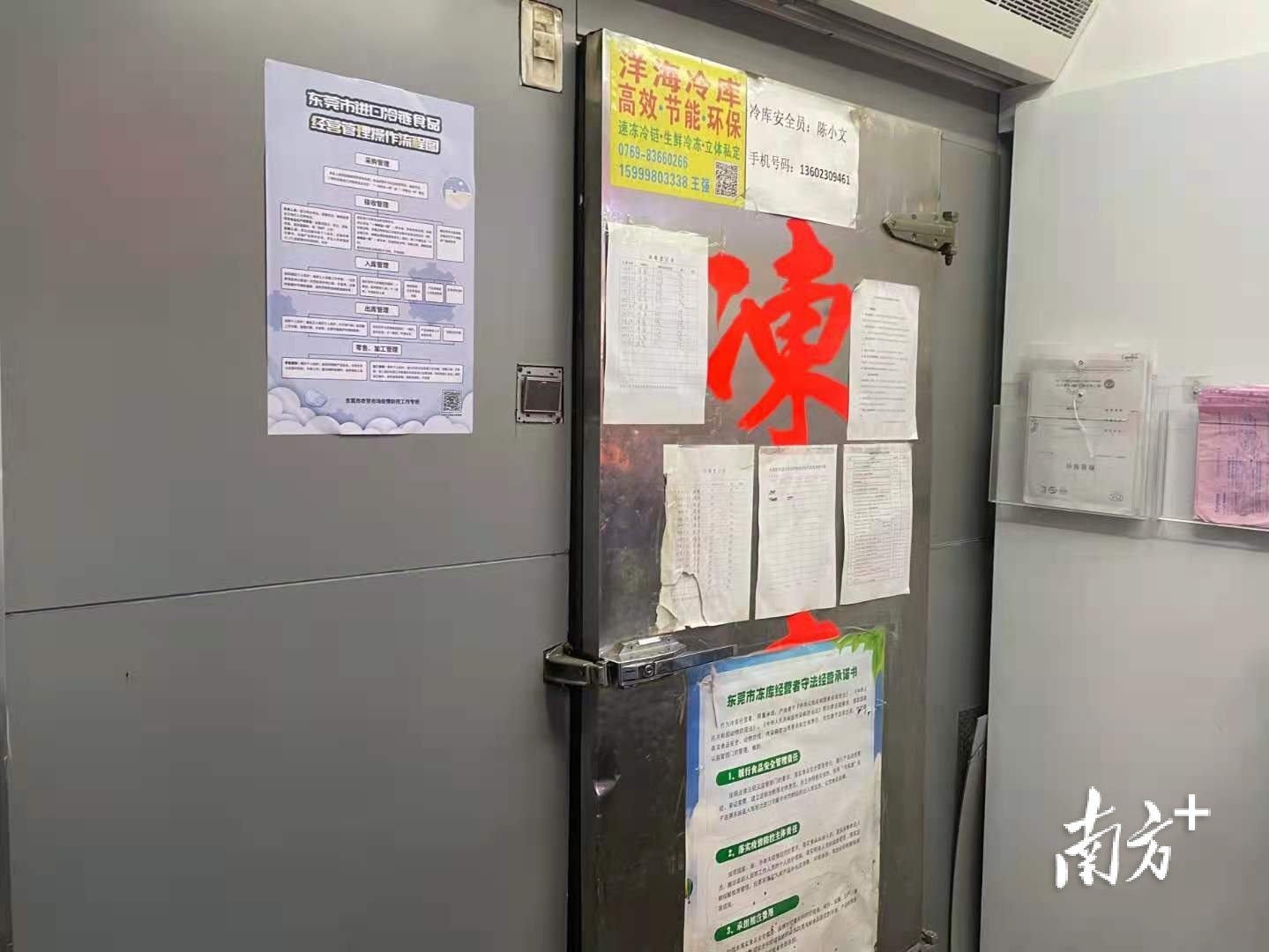 黄江镇江海城综合市场内一食品冷冻库墙上粘贴着《东莞市进口冷链食品经营管理操作流程图》等信息