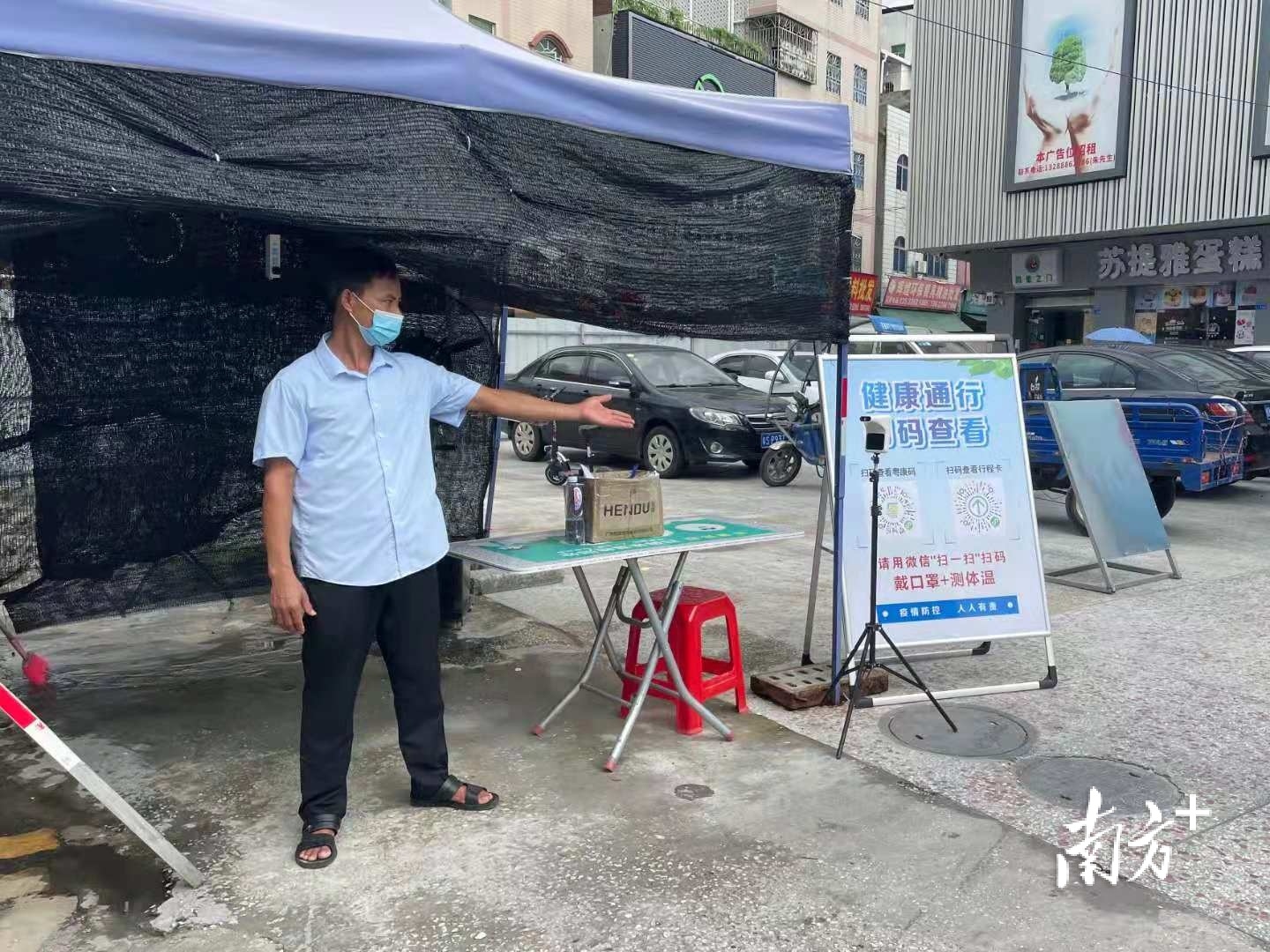 黄江镇江海城综合市场主要出入口有工作人员正在引导入场人员落实测温验码、佩戴口罩等健康管理措施